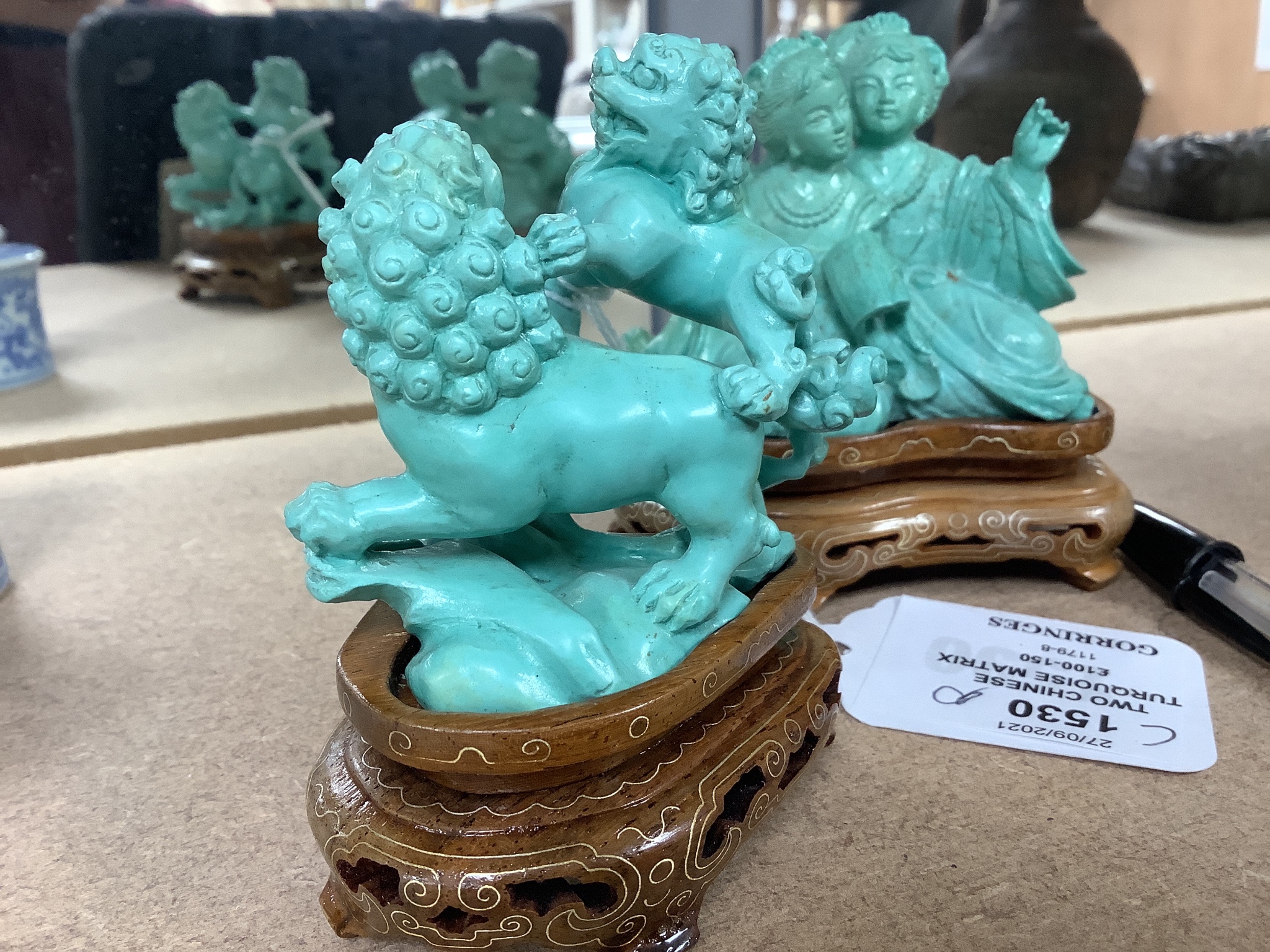 Two Chinese turquoise matrix groups of lion-dogs and of two kneeling ladies, mid 20th century, wood stands, height 9cm